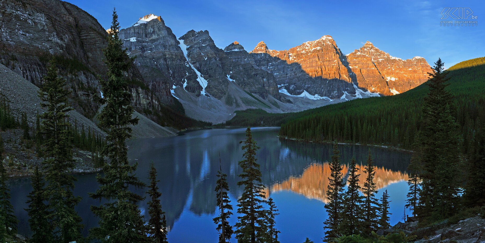 Banff NP - Lake Moraine - Zonsopgang Het eerste zonlicht in de morgen geeft een prachtige oranje gloed op de bergtoppen achter het mooie Lake Moraine. Dit meer is een van de iconische locaties in Banff nationaal park in de Rocky Mountains in Canada. Stefan Cruysberghs